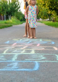Children jumping hopscotch on the street. Selective focus. kids.