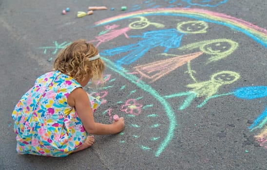 Children draw with chalk on the asphalt. Selective focus. kid.
