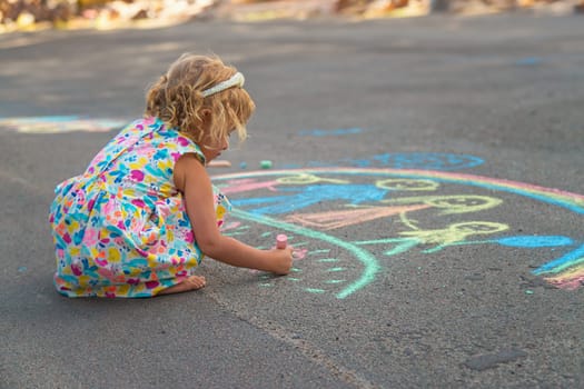 Children draw with chalk on the asphalt. Selective focus. kid.