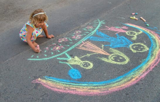 Children draw with chalk on the asphalt. Selective focus. kid.