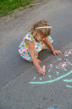 Children draw with chalk on the asphalt. Selective focus. kid.