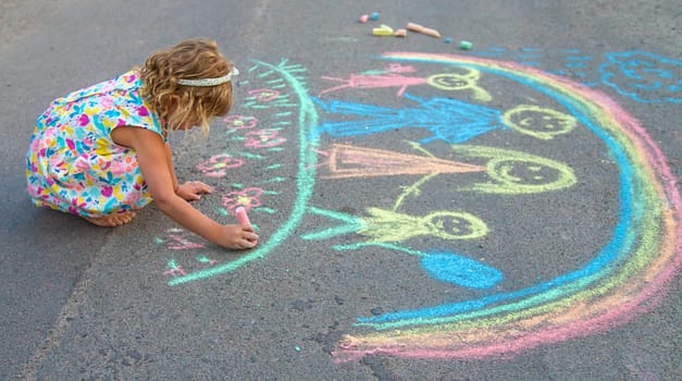 Children draw with chalk on the asphalt. Selective focus. kid.