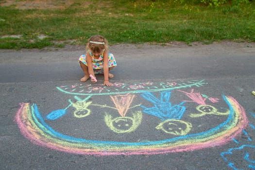 Children draw with chalk on the asphalt. Selective focus. kid.