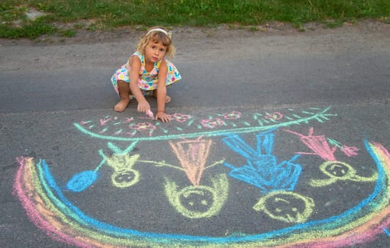 Children draw with chalk on the asphalt. Selective focus. kid.