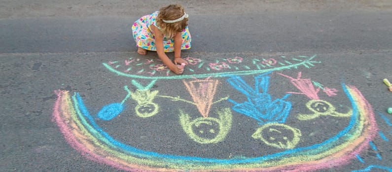 Children draw with chalk on the asphalt. Selective focus. kid.