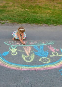 Children draw with chalk on the asphalt. Selective focus. kid.