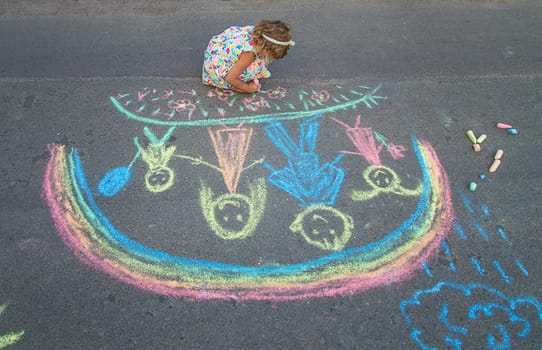 Children draw with chalk on the asphalt. Selective focus. kid.