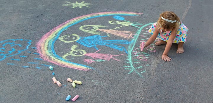 Children draw with chalk on the asphalt. Selective focus. kid.