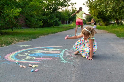 Children draw with chalk on the asphalt. Selective focus. kid.