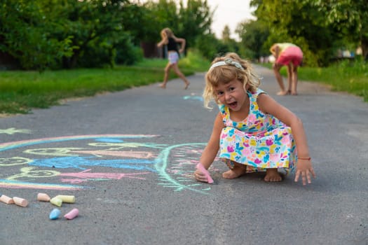 Children draw with chalk on the asphalt. Selective focus. kid.