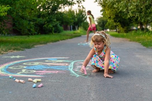 Children draw with chalk on the asphalt. Selective focus. kid.