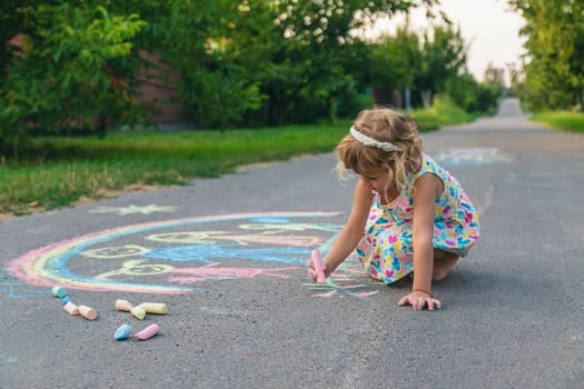 Children draw with chalk on the asphalt. Selective focus. kid.