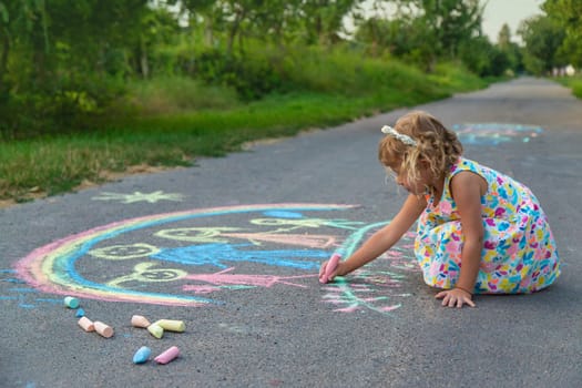 Children draw with chalk on the asphalt. Selective focus. kid.