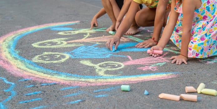 Children draw with chalk on the asphalt. Selective focus. kid.