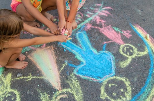 Children draw with chalk on the asphalt. Selective focus. kid.