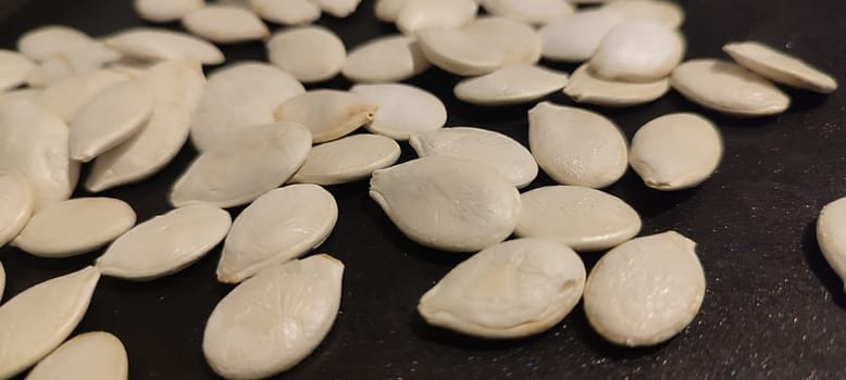 white pumpkin seeds healthy food in black pan. High quality photo