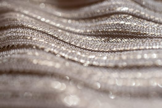 Silver glitter background material.Horizontal blurred metallic surface. Pure silver wire mesh. Wavy fabric with glitter. Used for backgrounds of fashion products