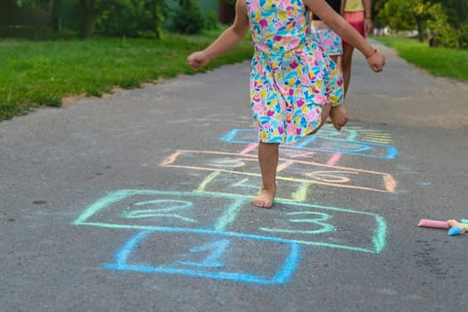 Children jumping hopscotch on the street. Selective focus. kids.