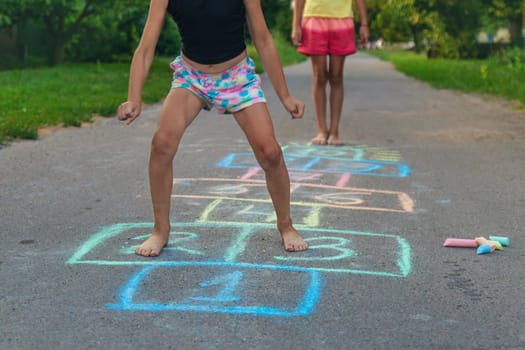 Children jumping hopscotch on the street. Selective focus. kids.