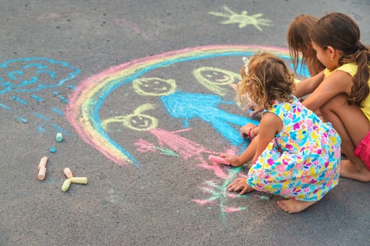 Children draw with chalk on the asphalt. Selective focus. kid.