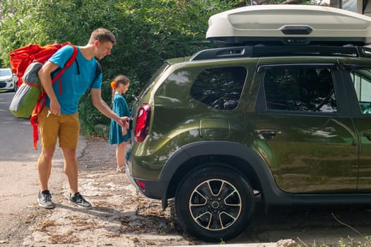 A man and a child happily loading their SUV with gear and supplies for an exciting outdoor excursion together