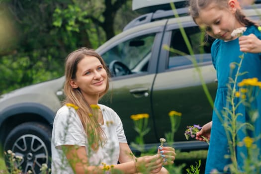 In a peaceful outdoor environment, a woman and a child share a delightful bond while exploring vibrant flowers