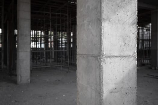 Amidst scaffolding, a fortified concrete column stands as the foundation for pouring concrete to lay the groundwork for the building's ongoing construction.