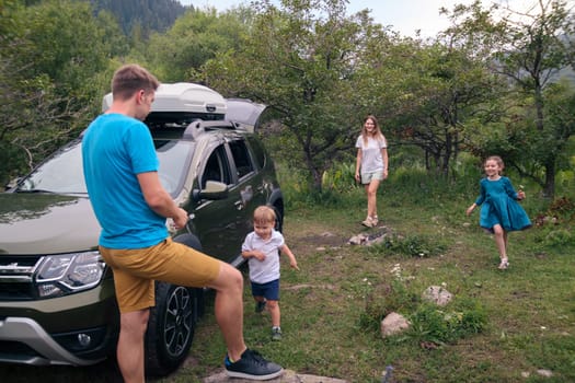 A joyful family happily enjoying quality time together outdoors, traveling in their car amidst beautiful nature