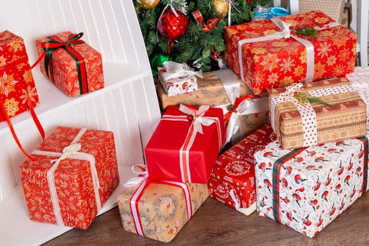 Stylish wrapped christmas gifts with ribbon on table on background of decorated christmas tree