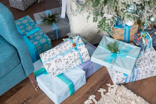 Stylish wrapped christmas gifts with ribbon on table on background of decorated christmas tree