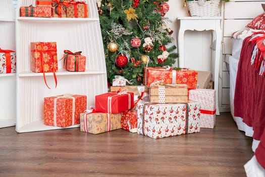 Stylish wrapped christmas gifts with ribbon on table on background of decorated christmas tree