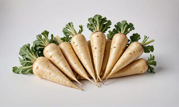 Nine white carrots with green tops are arranged in a semi-circle on a white background. The carrots are all facing the same direction and the tops are all pointing towards the top of the frame.