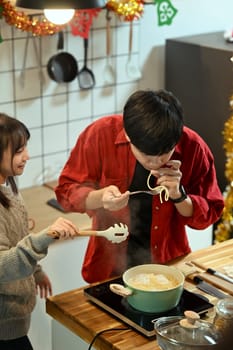 Happy couple preparing a festive meal together in a decorated kitchen.