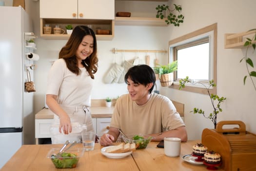 Couple enjoying breakfast and conversation in a cozy kitchen.