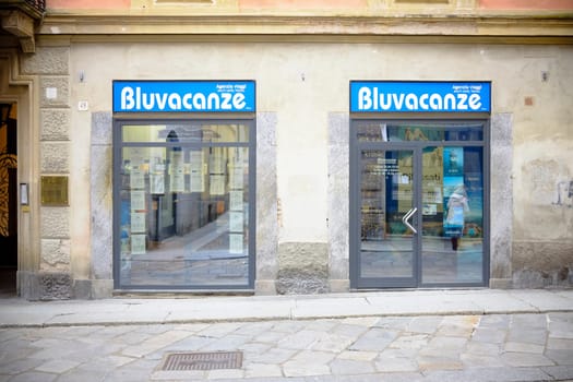 Cremona, Lombardy, Italy - November 7th 2024 Bluvacanze travel agency windows displaying holiday offers and packages in an italian cityscape