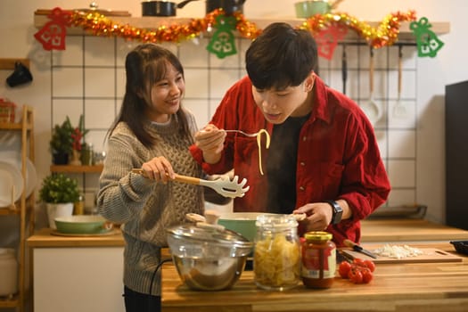 Happy couple preparing a festive meal together in a decorated kitchen.