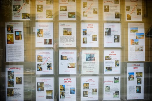 Cremona, Lombardy, Italy - November 7th 2024 Real estate agency window displaying numerous property listings with prices and locations