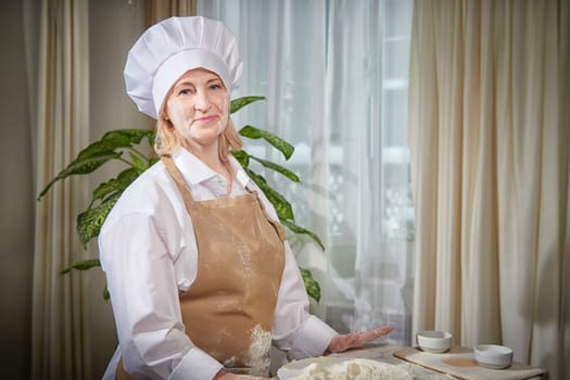 An elderly woman, dressed in a chef\'s outfit, playfully engages with flour at a fun home kitchen photo shoot.