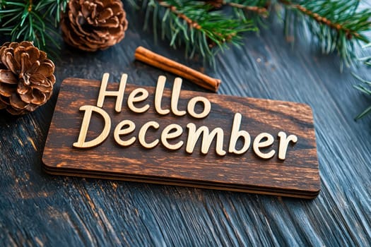 Hello December sign with rustic wooden background and pine cones.