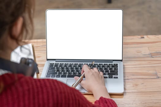 Image of female hand using and touching on laptop touchpad with blank white desktop screen..