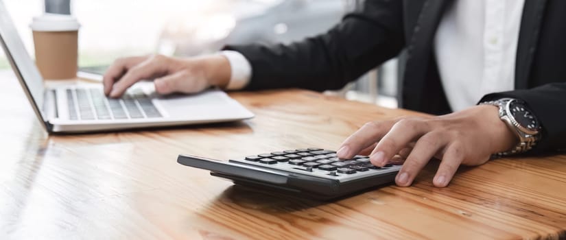 Business man using a calculator to calculate and analysis the company financial tax budget and income..