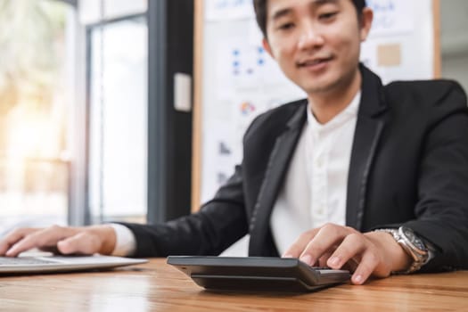 Business man using a calculator to calculate and analysis the company financial tax budget and income..