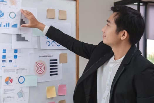 businessman presenting data analysis on a board to his colleagues in the company..