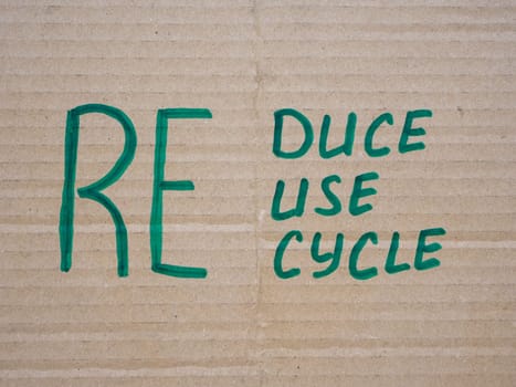 Handwritten words reduce, reuse and recycle on cardboard.