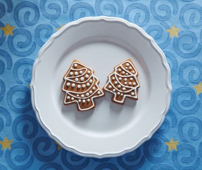 Painted gingerbread cookies in the shape of a Christmas tree on a plate