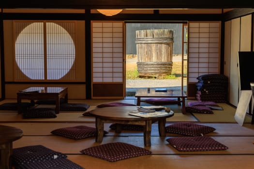 Large wooden barrel used for fermenting soy sauce outside traditional tatami room at historic soy sauce factory