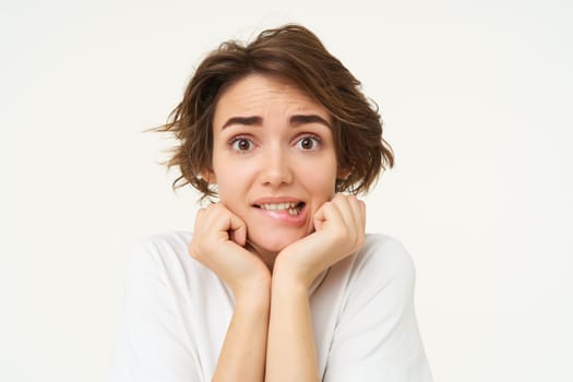 Close up of excited young brunette woman, looking with anticipation at camera, dreaming, wishing for something, isolated over white background.