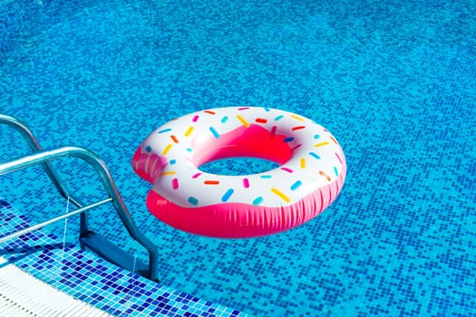 A cheerful inflatable ring inspired by a doughnut waits invitingly in the swimming pool