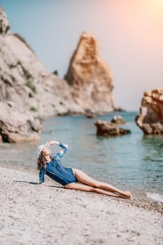 Young woman with black hair, fitness instructor in pink sports leggings and tops, doing pilates on yoga mat with magic pilates ring by the sea on the beach. Female fitness daily yoga concept