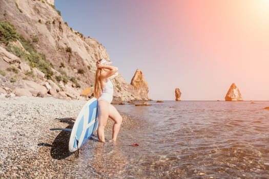 Close up shot of happy young caucasian woman looking at camera and smiling. Cute woman portrait in bikini posing on a volcanic rock high above the sea